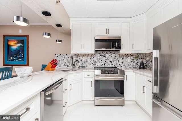 kitchen featuring tasteful backsplash, white cabinetry, hanging light fixtures, and appliances with stainless steel finishes