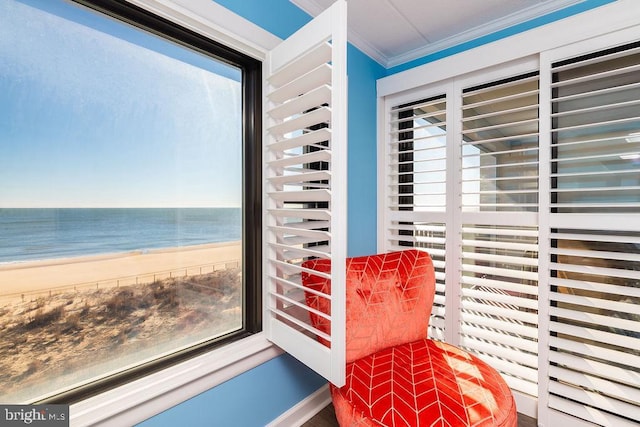 interior space featuring a beach view, a water view, and crown molding