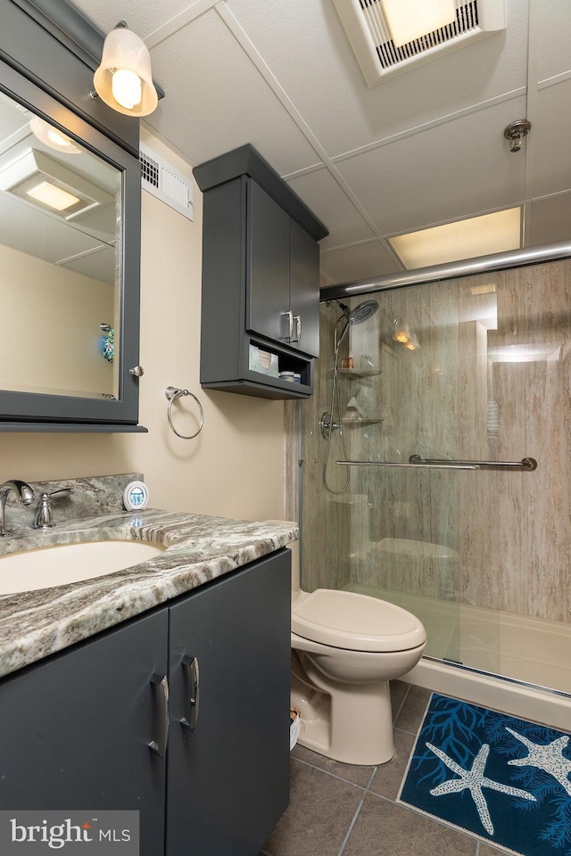 bathroom with tile patterned floors, vanity, toilet, and walk in shower