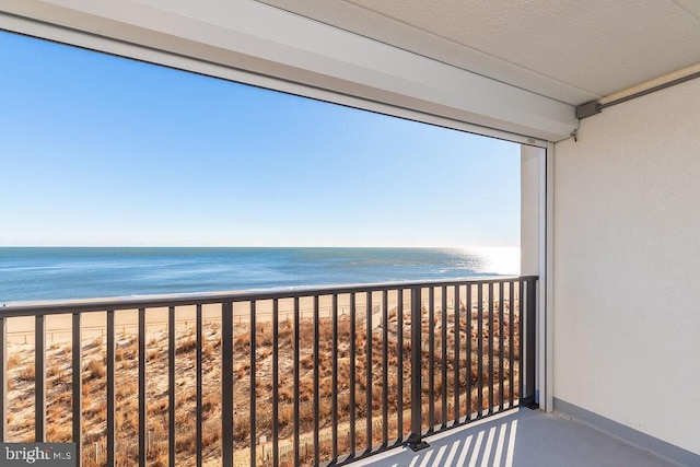 balcony featuring a water view and a beach view