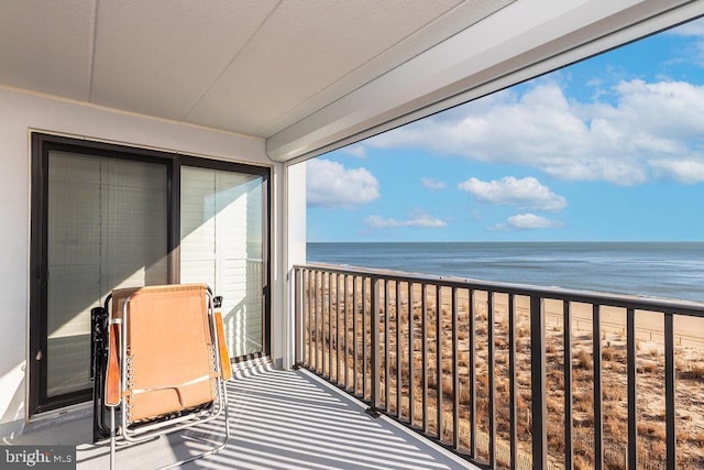 balcony featuring a water view and a view of the beach