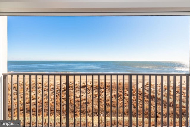 balcony featuring a view of the beach and a water view