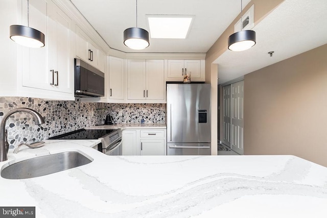 kitchen featuring light stone counters, sink, and stainless steel appliances