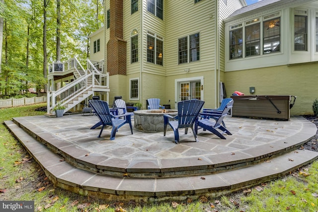 view of patio / terrace with a hot tub and an outdoor fire pit