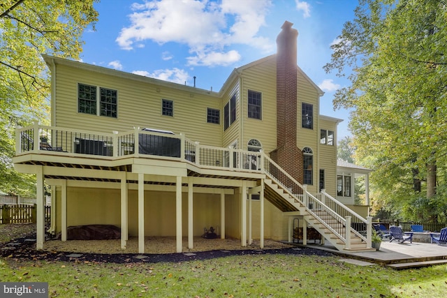 rear view of property featuring a yard and a wooden deck