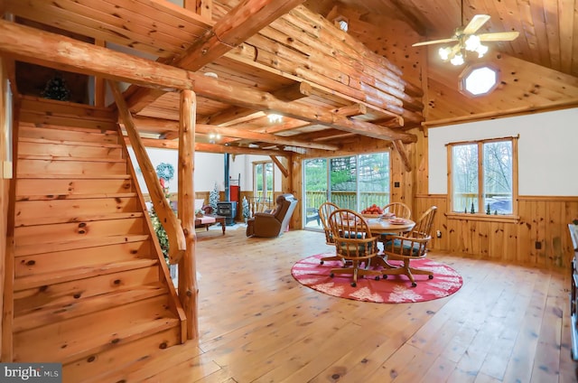 dining area featuring beamed ceiling, light wood-type flooring, ceiling fan, and wooden ceiling