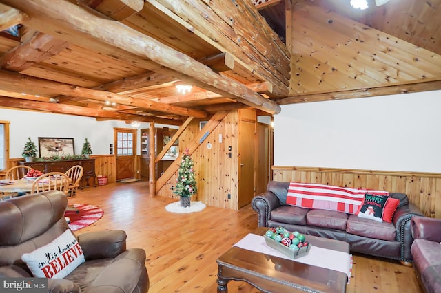 living room with beam ceiling, hardwood / wood-style flooring, wooden walls, and wood ceiling