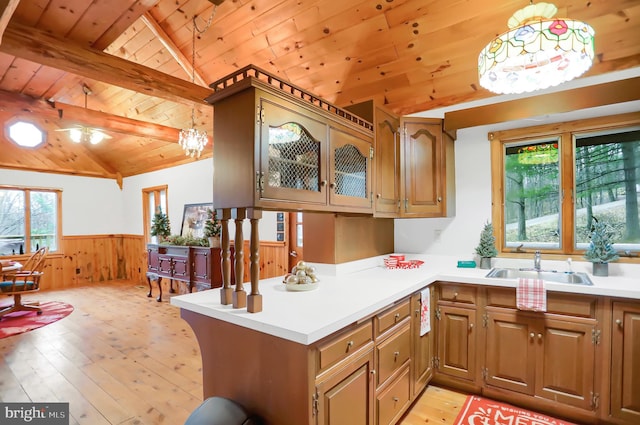 kitchen featuring wooden ceiling, hanging light fixtures, light hardwood / wood-style flooring, lofted ceiling with beams, and kitchen peninsula