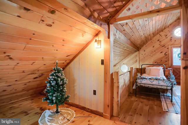 additional living space with vaulted ceiling with beams, wooden walls, light hardwood / wood-style flooring, and wood ceiling