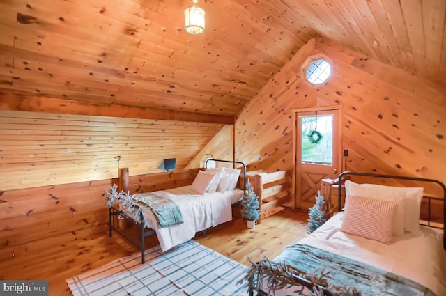 bedroom with lofted ceiling, wooden ceiling, wooden walls, and light hardwood / wood-style flooring