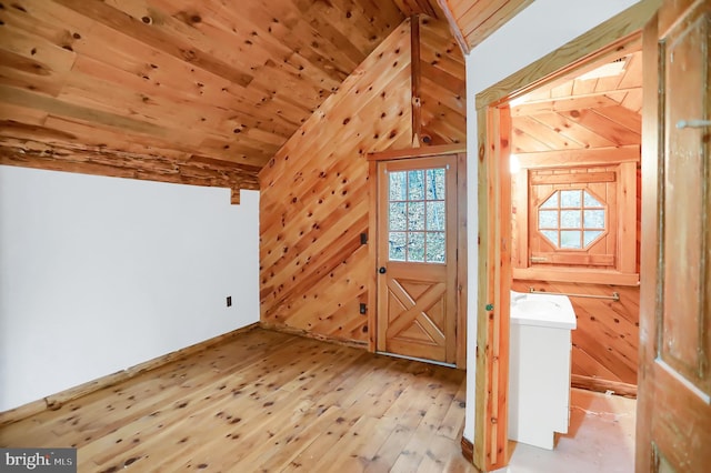 interior space featuring wooden walls, light hardwood / wood-style floors, lofted ceiling, and wood ceiling