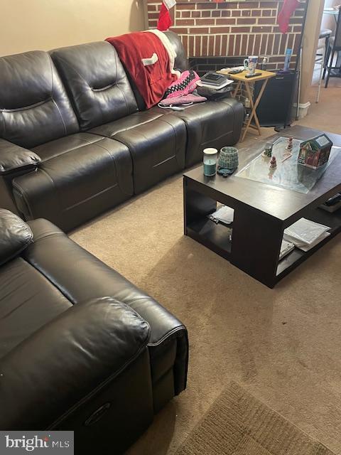 carpeted living room with a brick fireplace