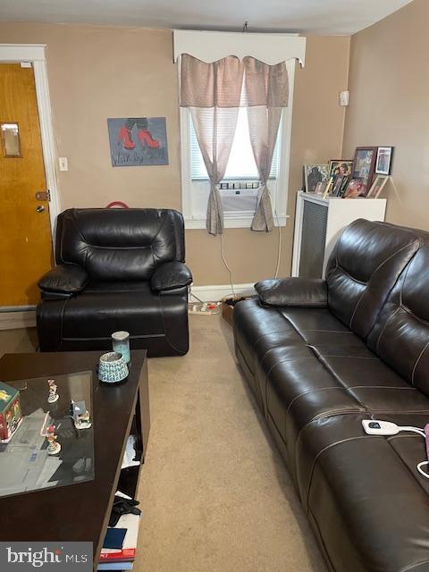 living room with carpet, cooling unit, and baseboard heating