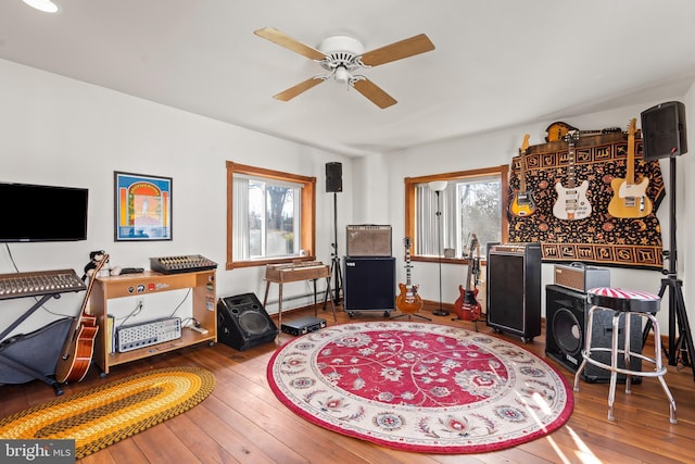 interior space featuring ceiling fan, hardwood / wood-style floors, and a baseboard heating unit