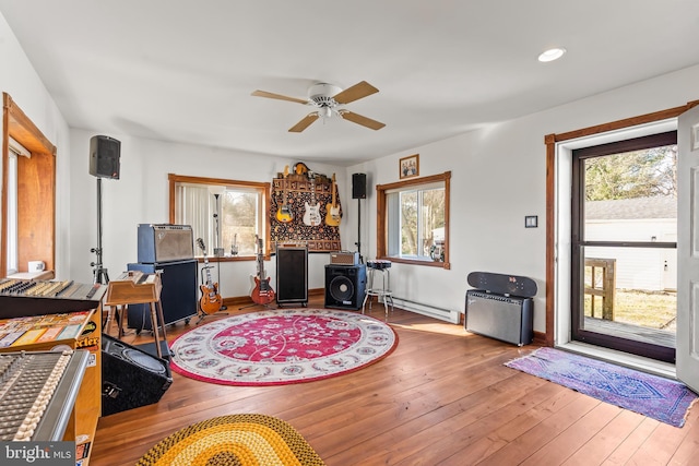 interior space with hardwood / wood-style floors, a baseboard radiator, and ceiling fan