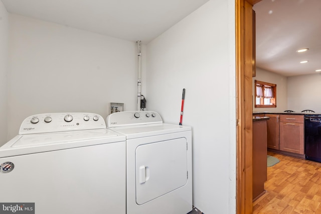 laundry area featuring light hardwood / wood-style floors and washing machine and clothes dryer