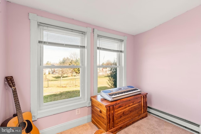 interior space with light carpet, plenty of natural light, and a baseboard heating unit