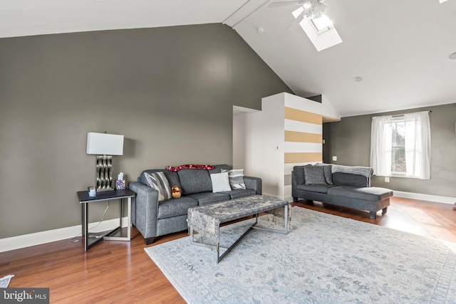 living room featuring a skylight, ceiling fan, high vaulted ceiling, and hardwood / wood-style flooring