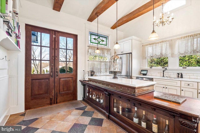 kitchen featuring white cabinetry, french doors, beamed ceiling, and stainless steel appliances