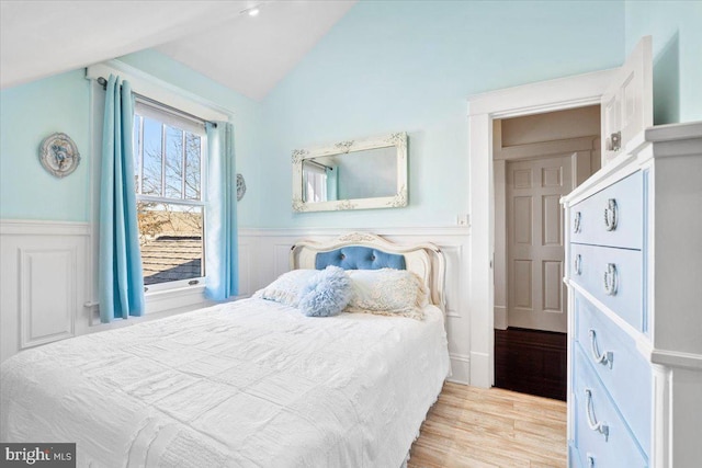 bedroom with light hardwood / wood-style flooring and lofted ceiling