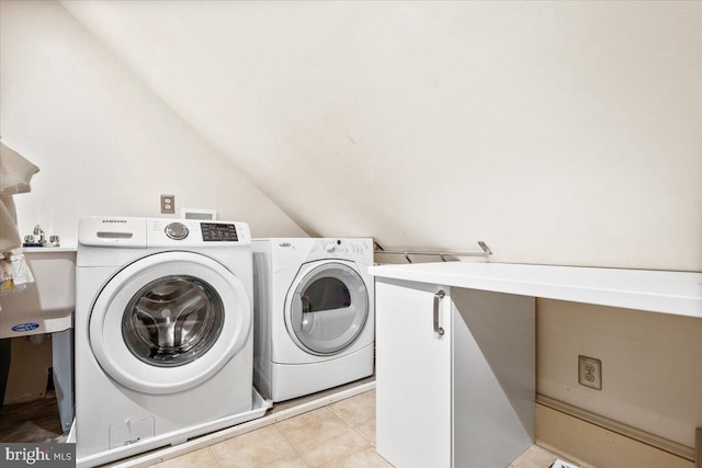 laundry room featuring washer and dryer, light tile patterned floors, and cabinets