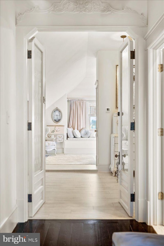 corridor featuring hardwood / wood-style floors and vaulted ceiling