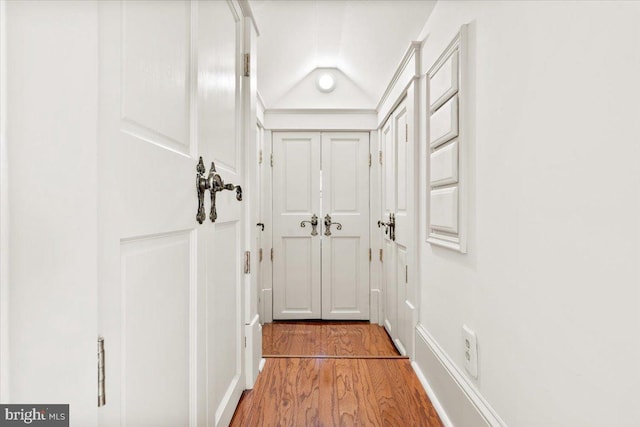 doorway featuring hardwood / wood-style floors and lofted ceiling