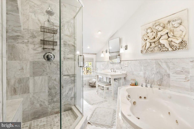 bathroom featuring independent shower and bath, tile walls, and lofted ceiling