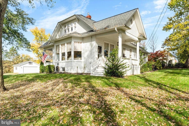 view of side of home with a garage, an outdoor structure, and a lawn