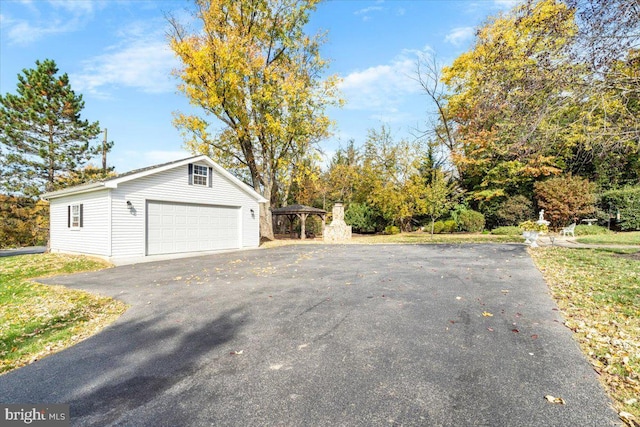 view of side of home with a carport, a garage, and an outbuilding