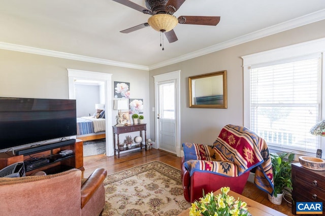 living room with a wealth of natural light, hardwood / wood-style floors, and crown molding