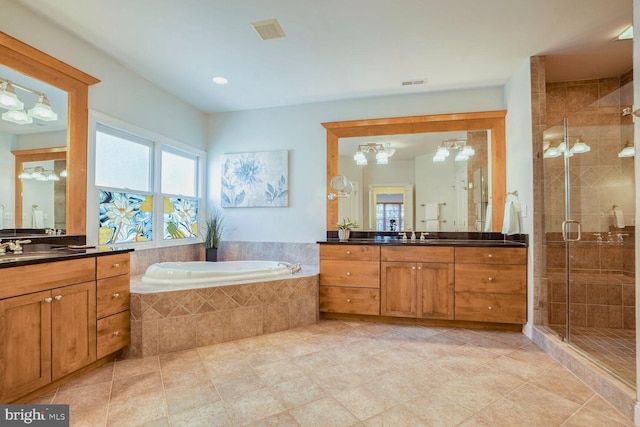 bathroom with vanity, tile patterned flooring, and plus walk in shower