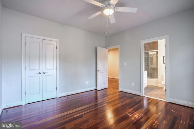 unfurnished bedroom with dark hardwood / wood-style flooring, a closet, ensuite bath, and ceiling fan