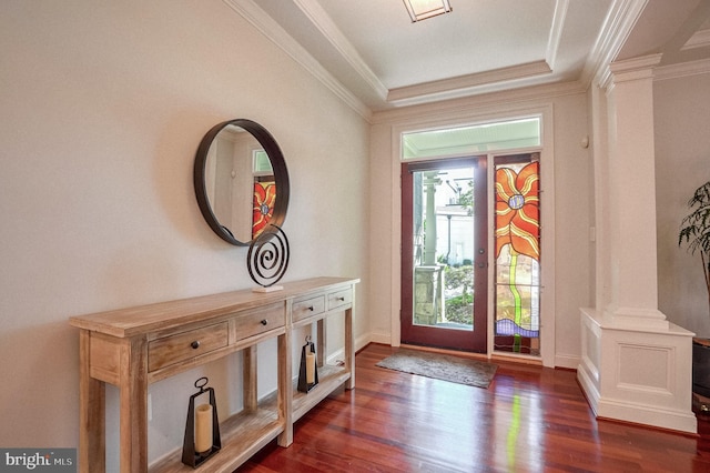 entrance foyer featuring ornate columns, dark wood-type flooring, and ornamental molding