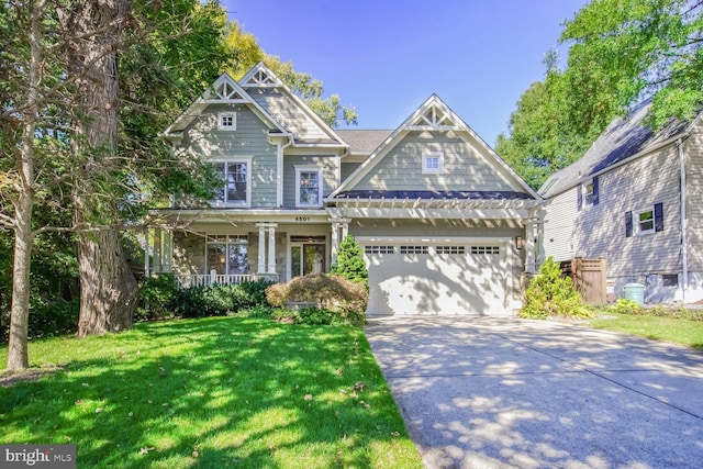 craftsman-style home featuring covered porch, a garage, and a front yard