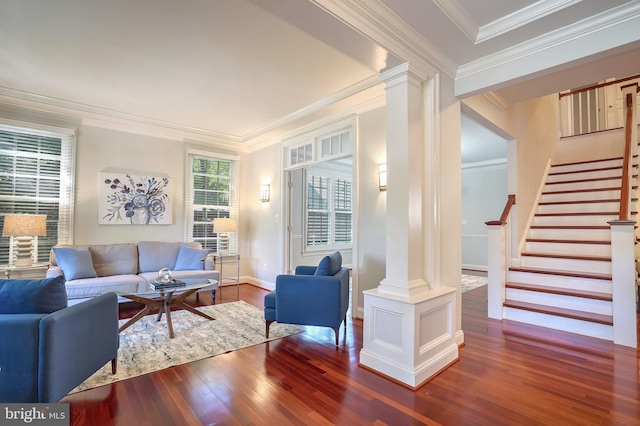 living room featuring dark hardwood / wood-style flooring, ornate columns, and ornamental molding