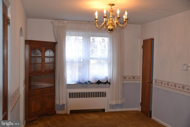 carpeted dining room featuring an inviting chandelier and radiator