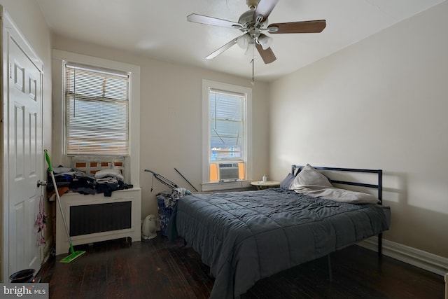 bedroom with ceiling fan, cooling unit, and dark wood-type flooring