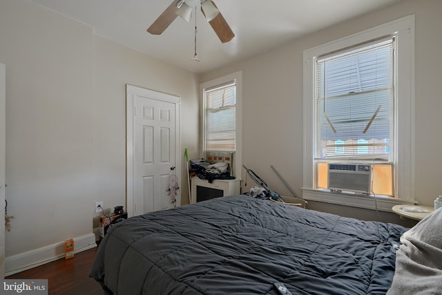 bedroom with ceiling fan, cooling unit, and dark hardwood / wood-style flooring