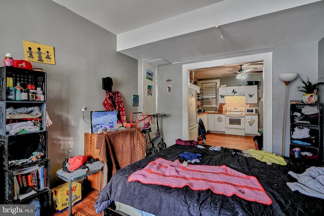 bedroom featuring white fridge and light hardwood / wood-style flooring