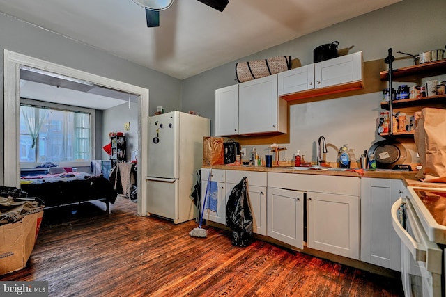 kitchen featuring white cabinets, sink, white fridge, and stove