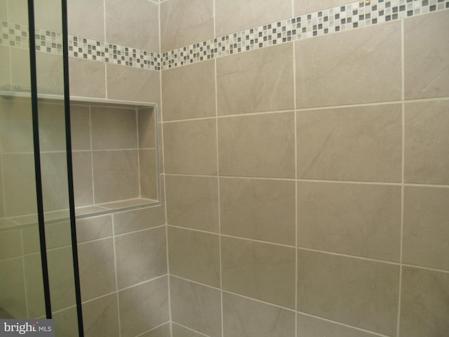 interior details featuring tiled shower