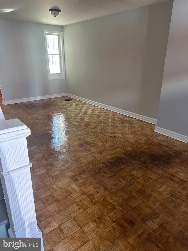 unfurnished room featuring dark parquet flooring