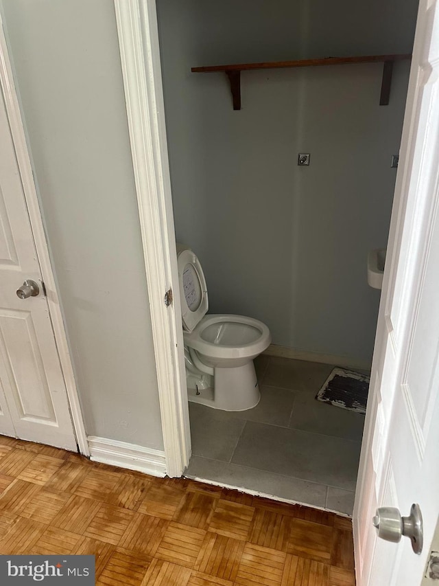 bathroom with parquet floors and toilet