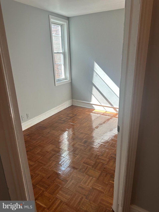 spare room with dark parquet flooring