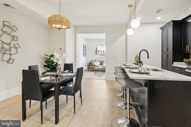 dining space featuring sink and light hardwood / wood-style flooring