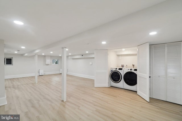 interior space with washing machine and clothes dryer, radiator, and light hardwood / wood-style floors