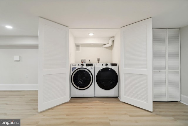 laundry room with light wood-type flooring and independent washer and dryer