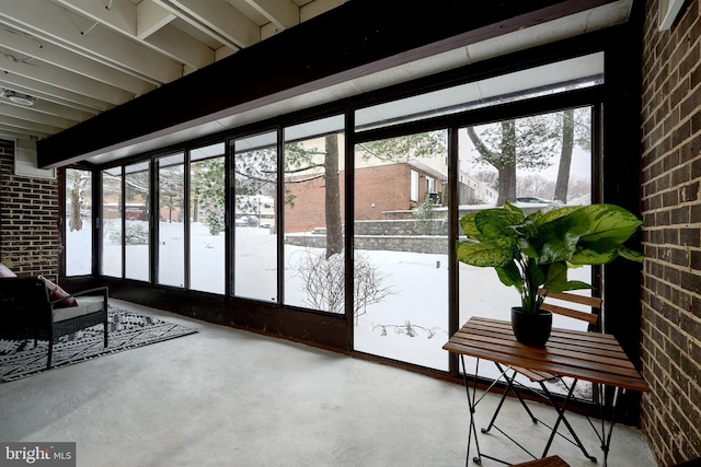 entryway featuring brick wall and concrete floors