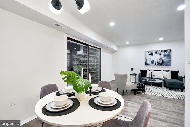 dining room featuring a textured ceiling and hardwood / wood-style flooring